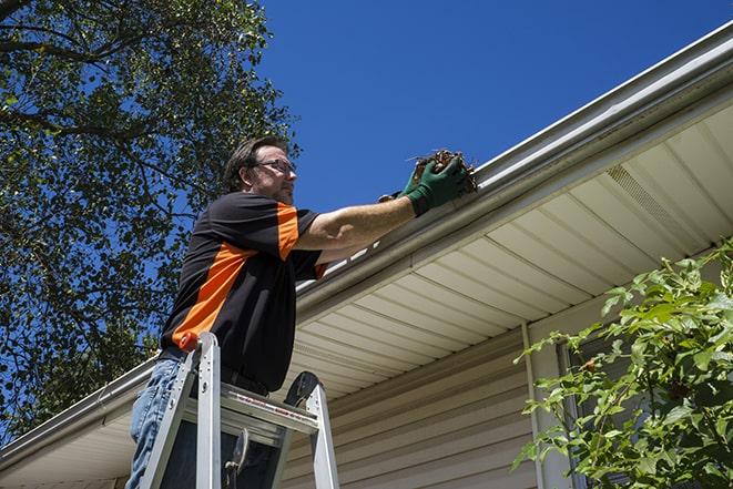 gutter repairman fixing a leaky drain in Bloomingdale, IL